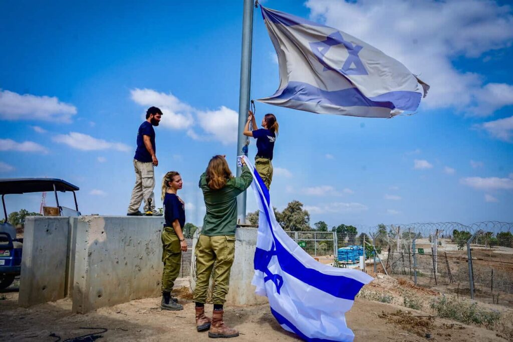 Israeli soldiers raise flag in Western Negev communities impacted by October 7.
